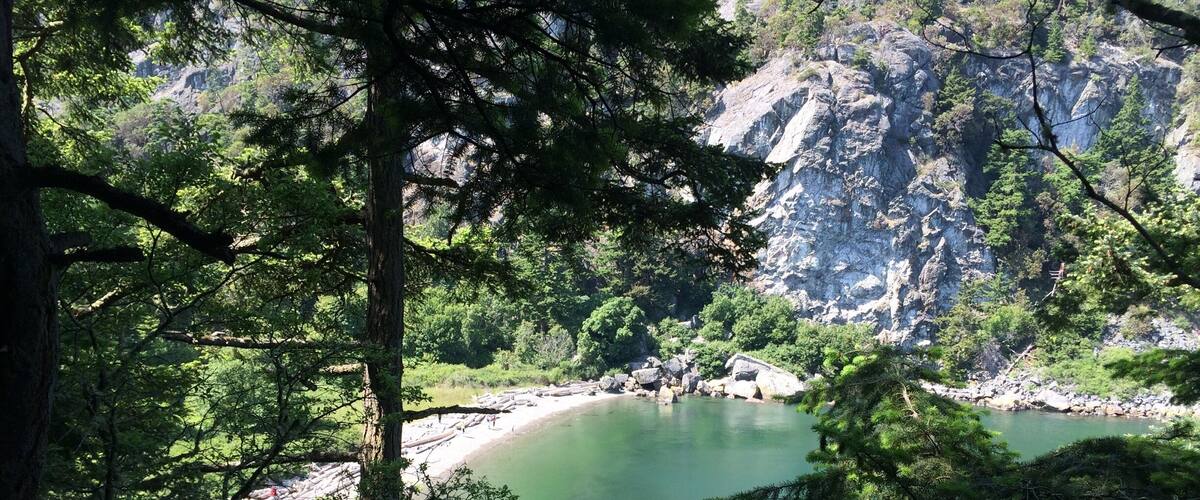 This is Watmough Beach on Lopez in the San Juans. Beautiful peaceful beach with cliffs above and short kid friendly trails as well. At lower tides take the trail out to tide pools and perfect skipping stones that have formed from the currents! I love this place!