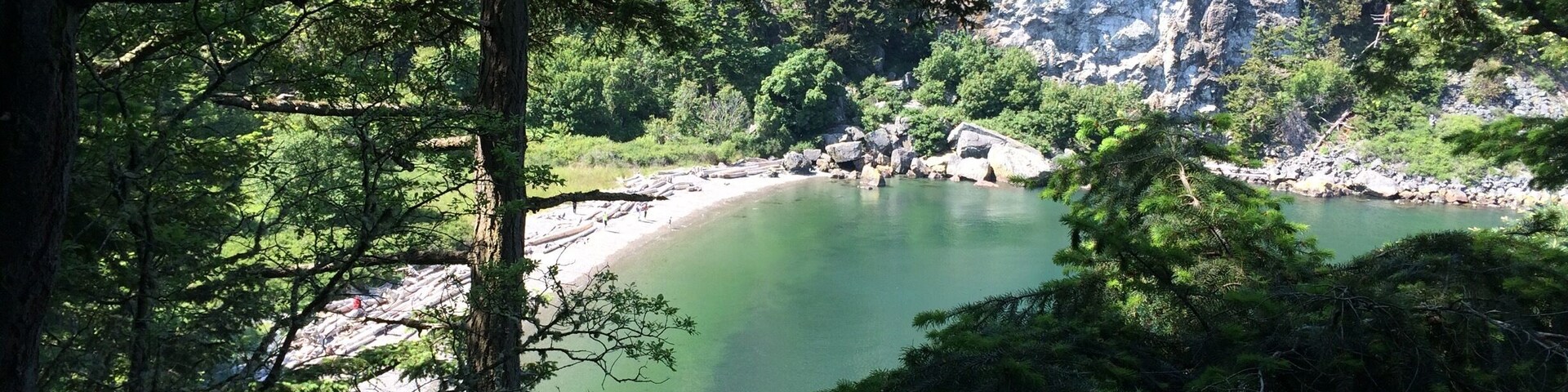 This is Watmough Beach on Lopez in the San Juans. Beautiful peaceful beach with cliffs above and short kid friendly trails as well. At lower tides take the trail out to tide pools and perfect skipping stones that have formed from the currents! I love this place!