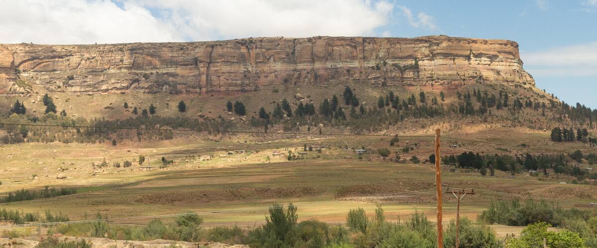 A flat-topped butte with sparse vegetation and a clear sky.