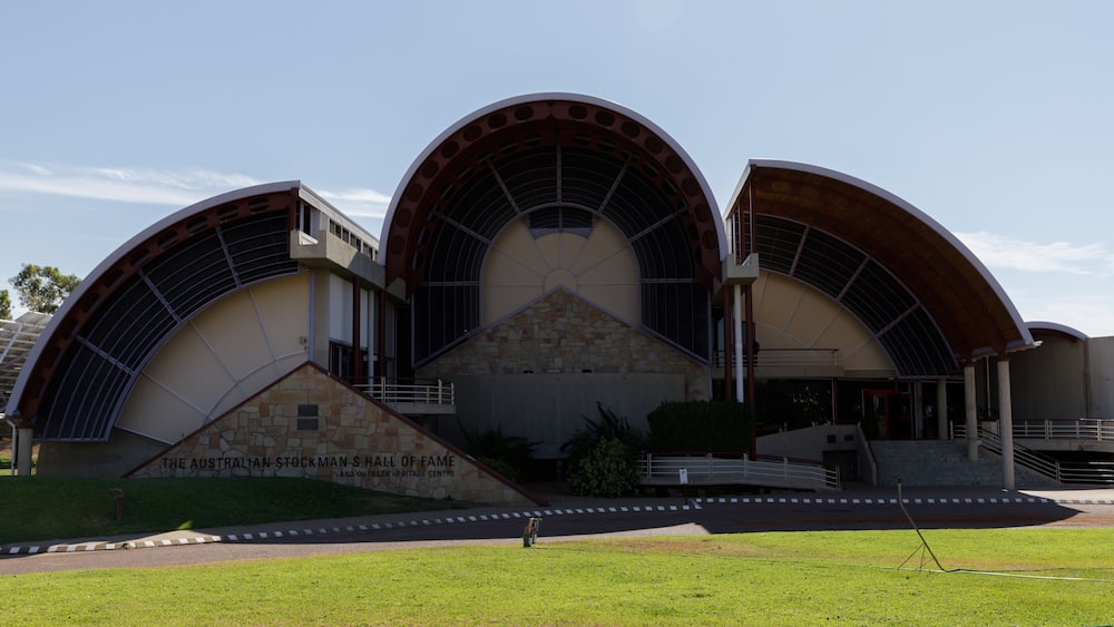 A modern building with a curved roof and a stone base, labeled 'The Australian Stockman Hall of Fame.'