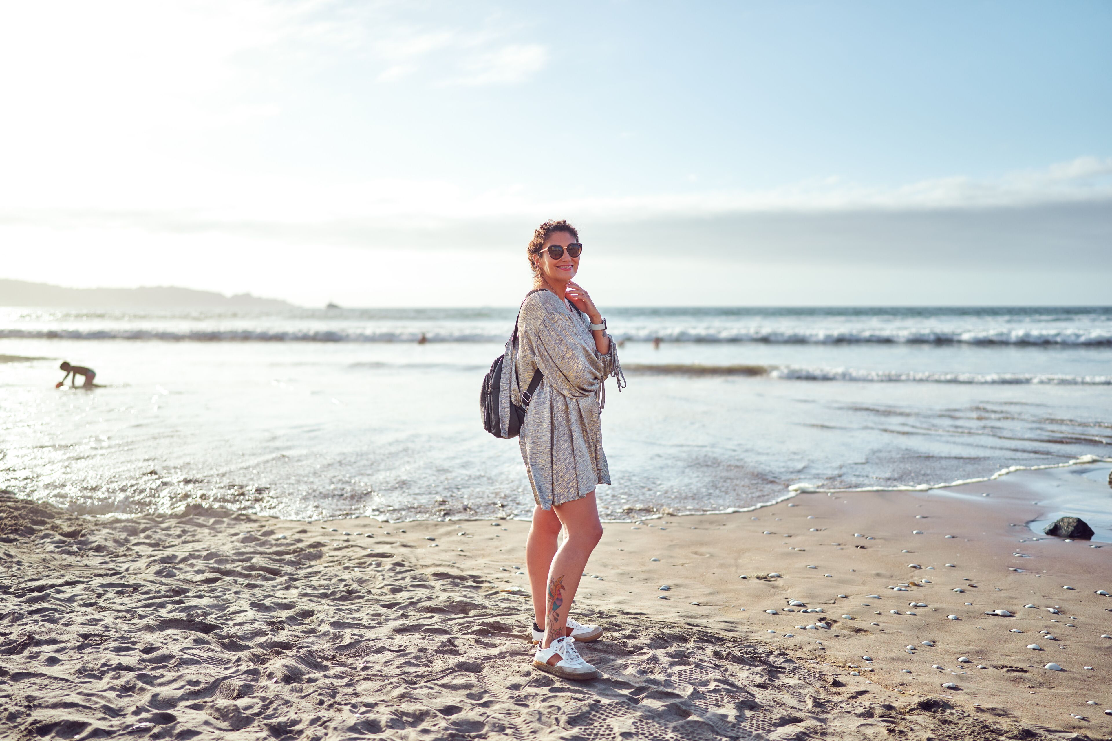 Carefree woman walking on the beach at sunset enjoying summer vacation in La Serena, Coquimbo region 