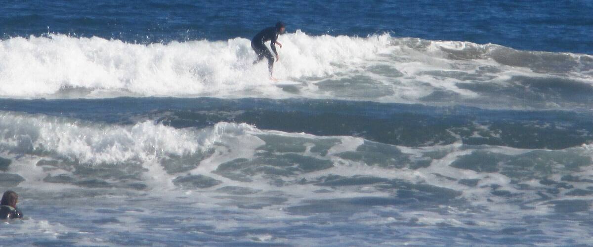 Surfers riding the waves in front of the beach in La Serena, Chile