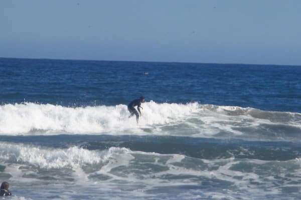 Surfers riding the waves in front of the beach in La Serena, Chile