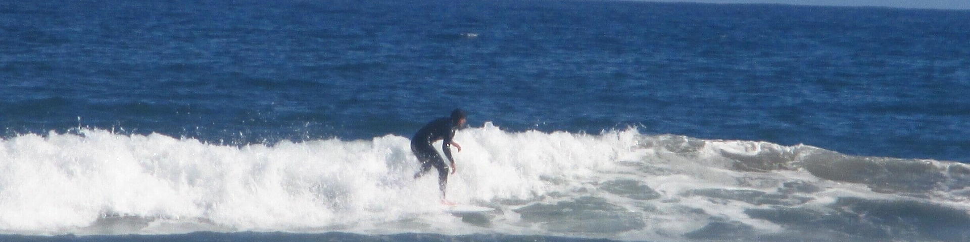 Surfers riding the waves in front of the beach in La Serena, Chile