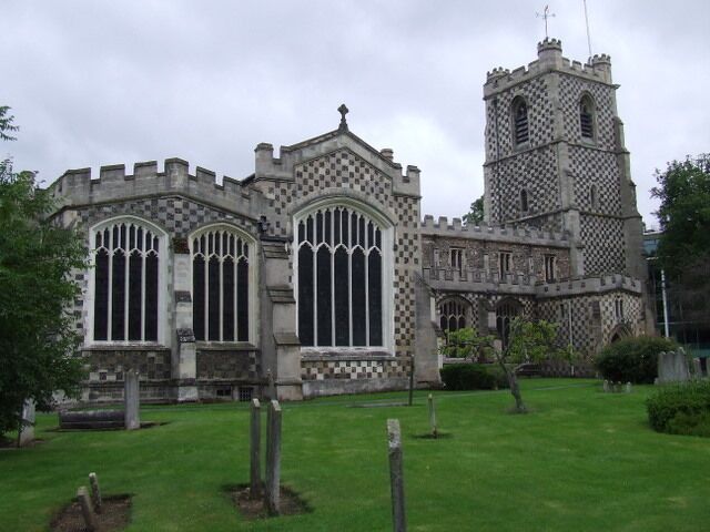 A historic church with large arched windows and a tall tower.