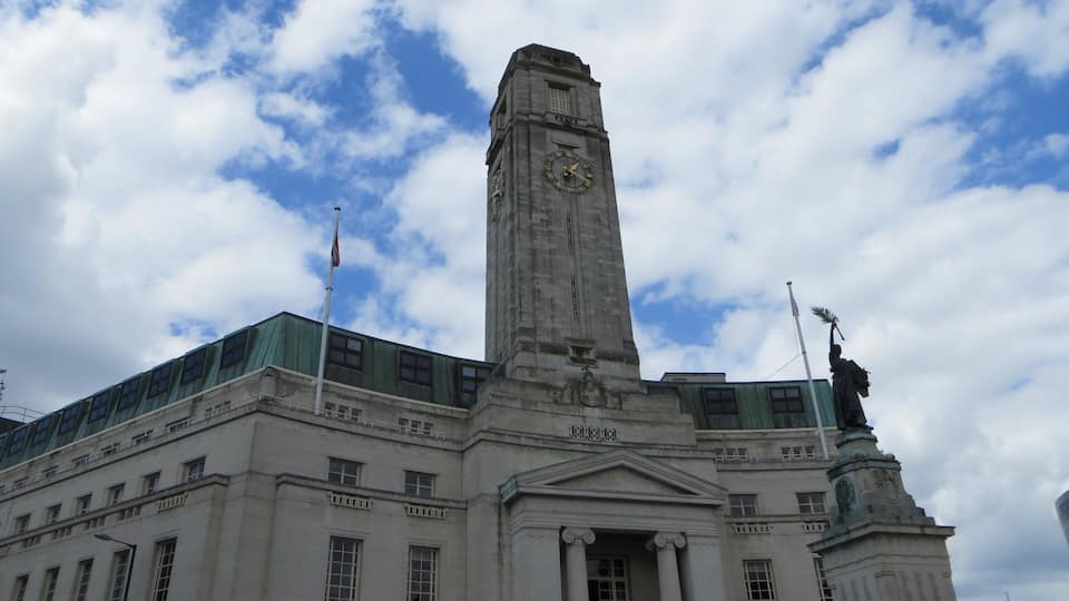 A historic building with a clock tower and a statue of Liberty.