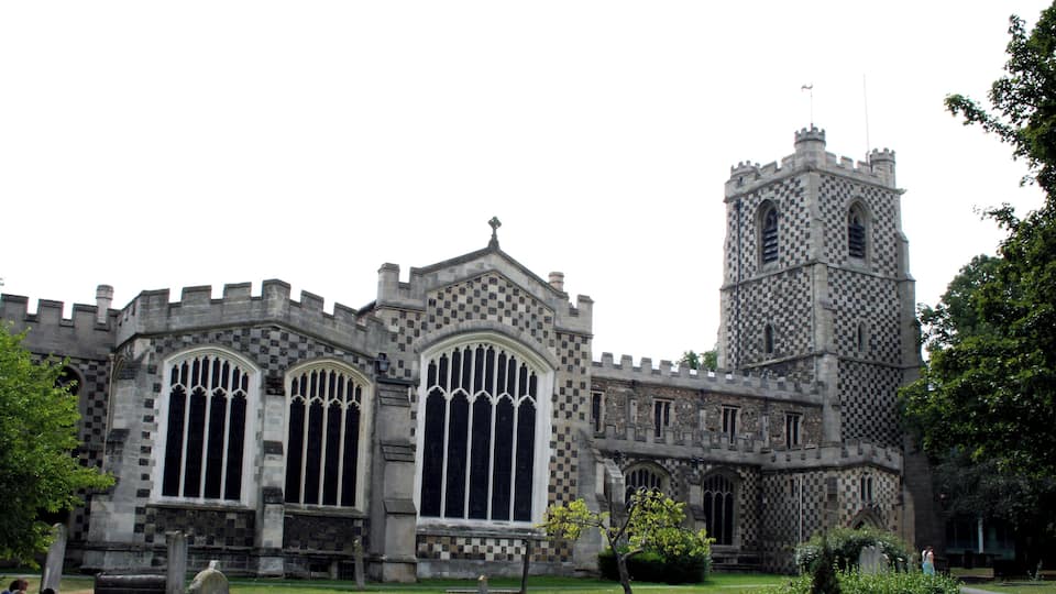 A historic church with a tall tower and large arched windows.
