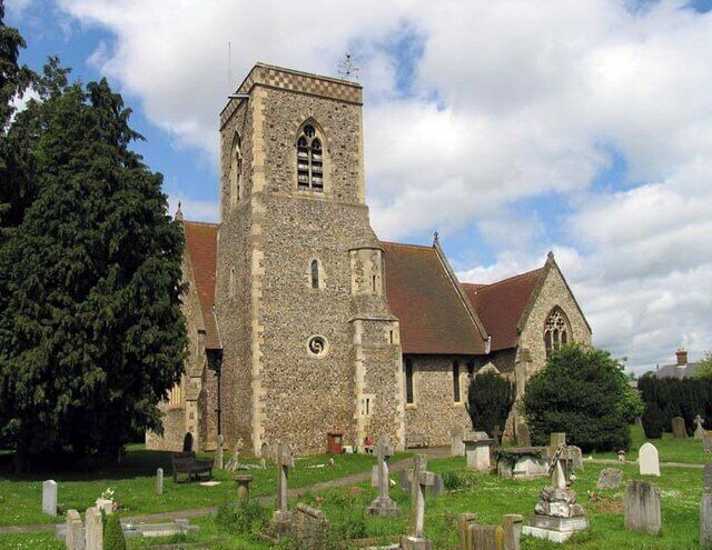 A historic church with a tall tower, surrounded by a cemetery.