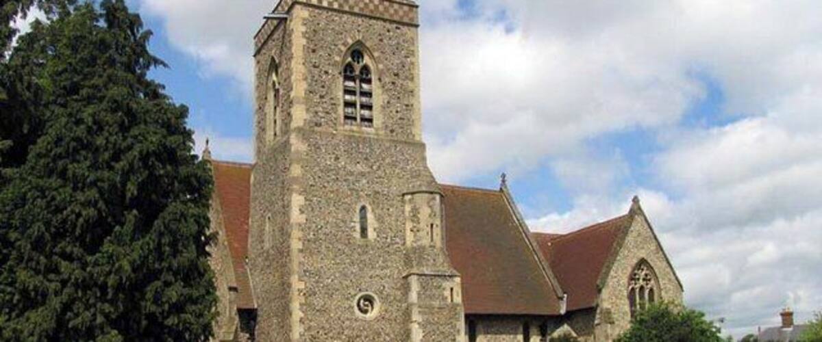 A historic church with a tall tower, surrounded by a cemetery.