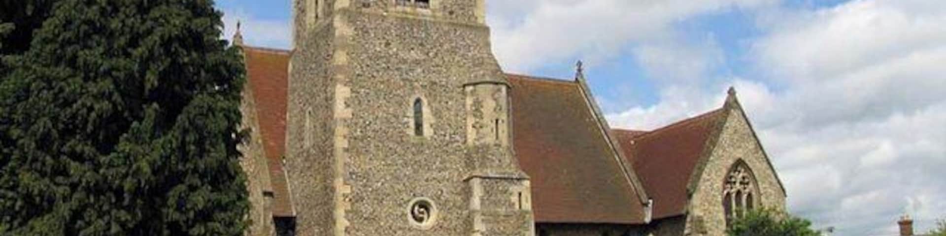 A historic church with a tall tower, surrounded by a cemetery.