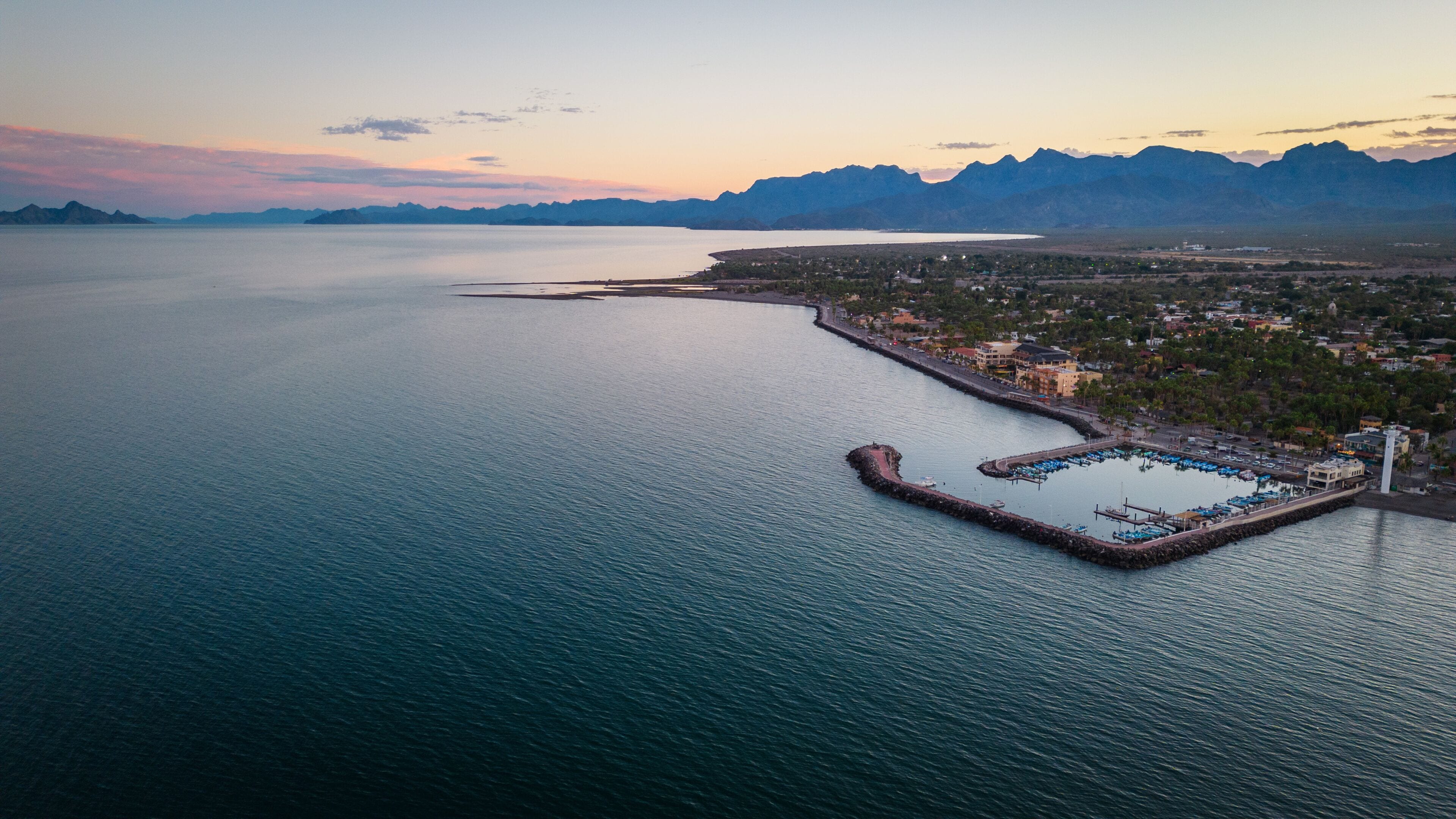 drone fly above Loreto Baja California Sur Mexico old colonial town with sea gulf ocean and mountains desert landscape at sunset
