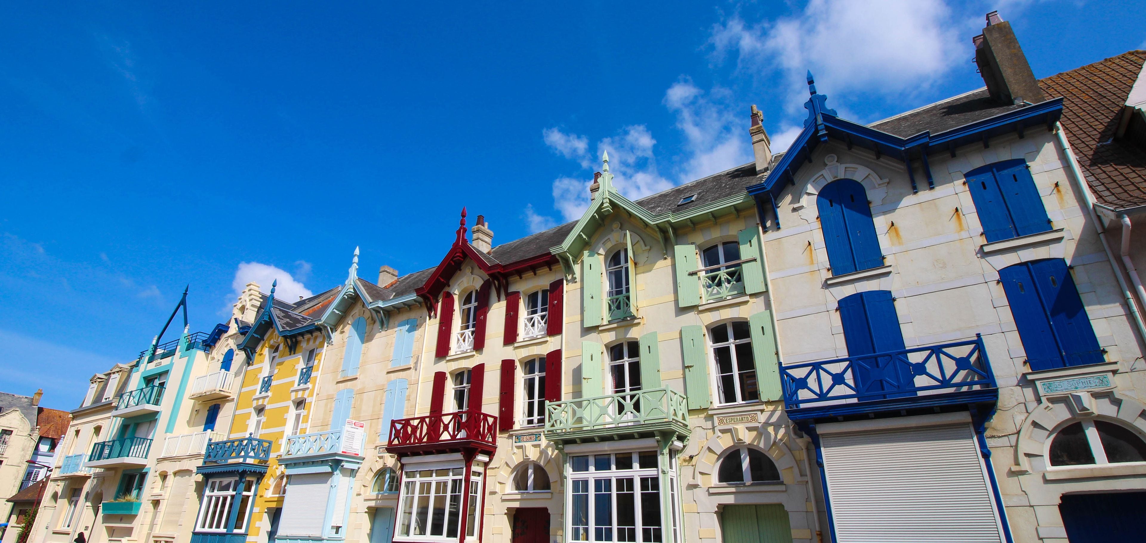 A row of colorful buildings with distinct architectural styles and balconies.