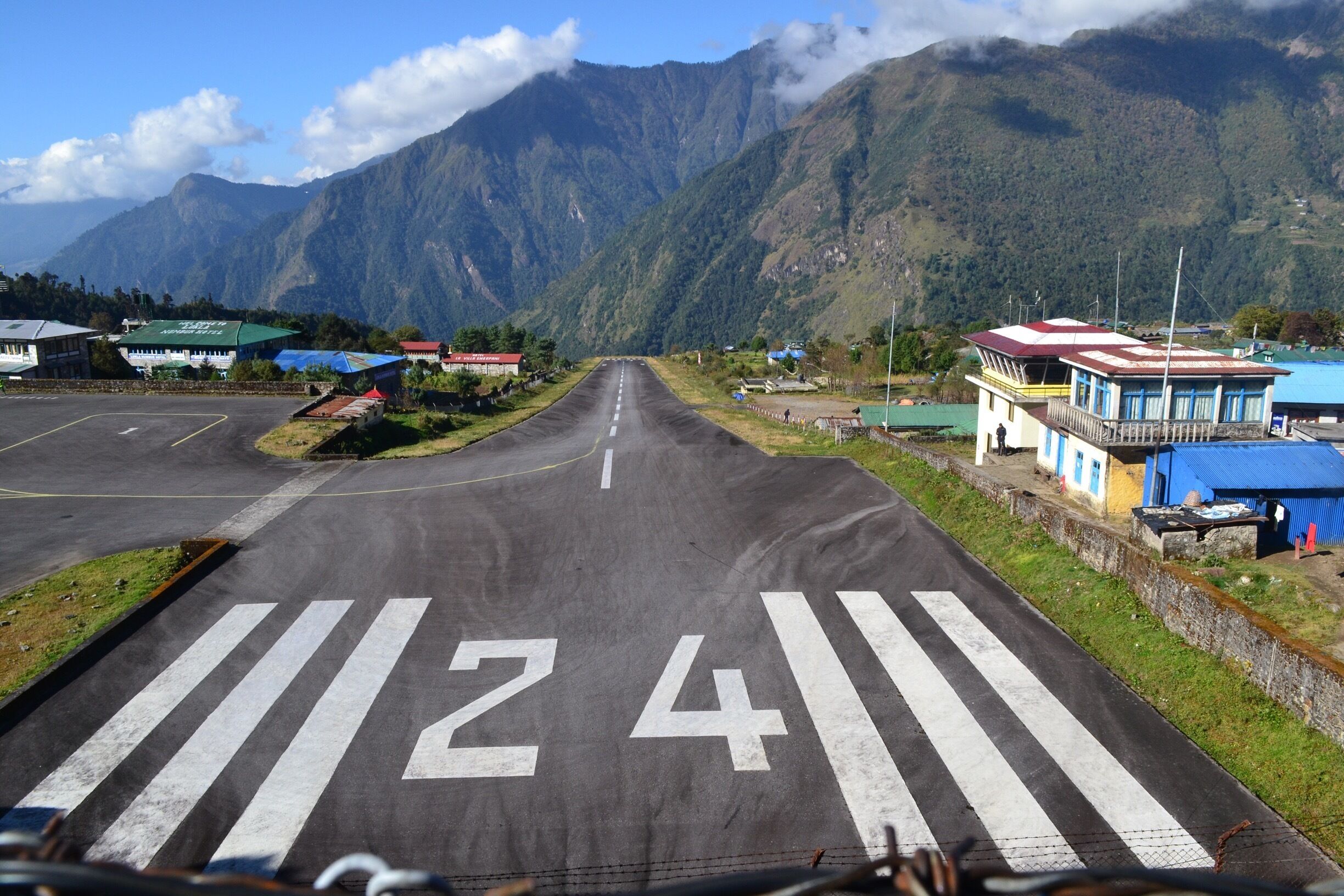 Lukla Airport one of most dangerous air strips in the world. Only 460 meters in length with a 50 meter elevation change from the bottom of the runway to the top and about a 9000 ft drop off at the end of the runway. 