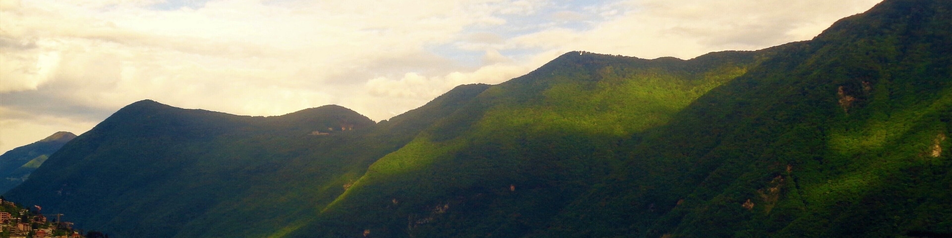 Lake Lugano in Ticino, Switzerland. This is a lush green view from Lugano city. It's the largest city in the Italian-speaking canton of Ticino (but still only the 9th largest city in Switzerland). The city has impressive culture and history but what most stands out are the natural views! I also went up to Monte Brè and Monte San Salvatore right by Lugano. The views from there are even more impressive!