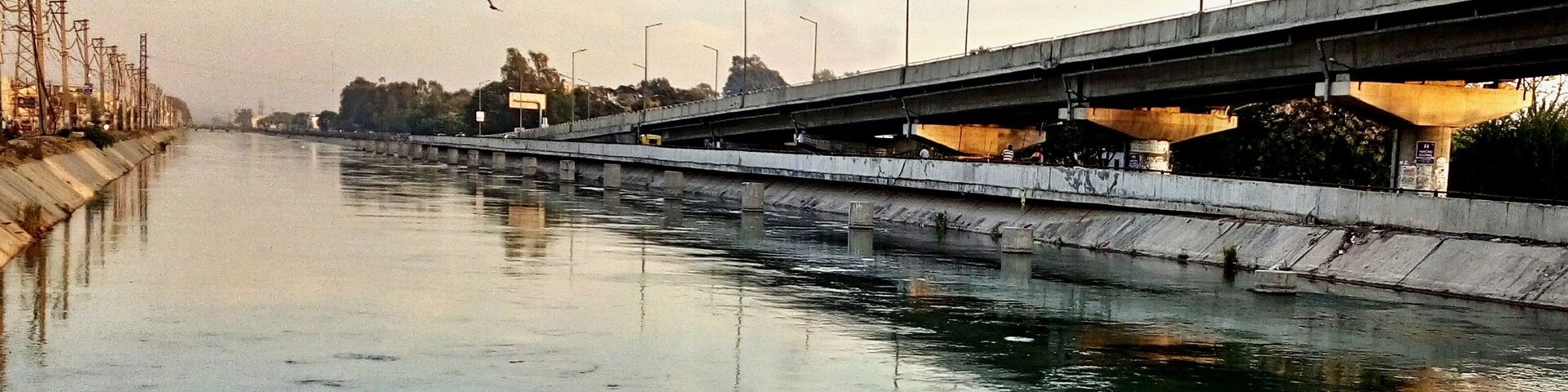 Un río con un puente de hormigón sobre él.