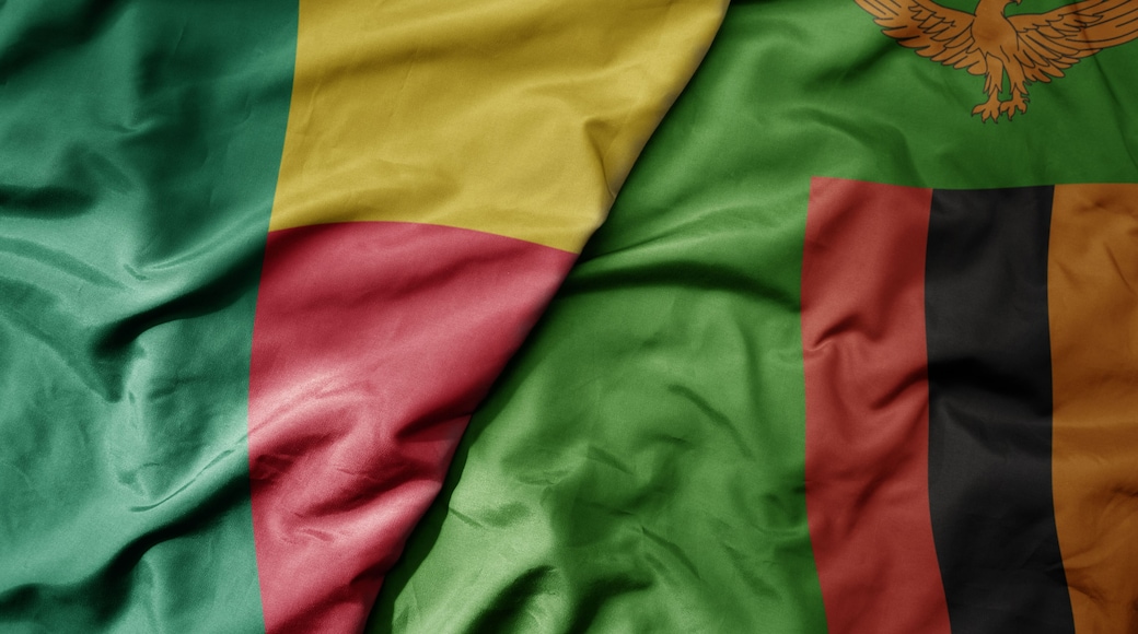 big waving national colorful flag of benin and national flag of zambia .