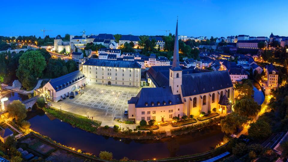 A historic town with a prominent church, a river, and a castle-like structure.