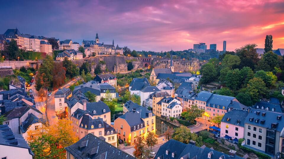 A historic town with a prominent castle, a river, and a bridge.