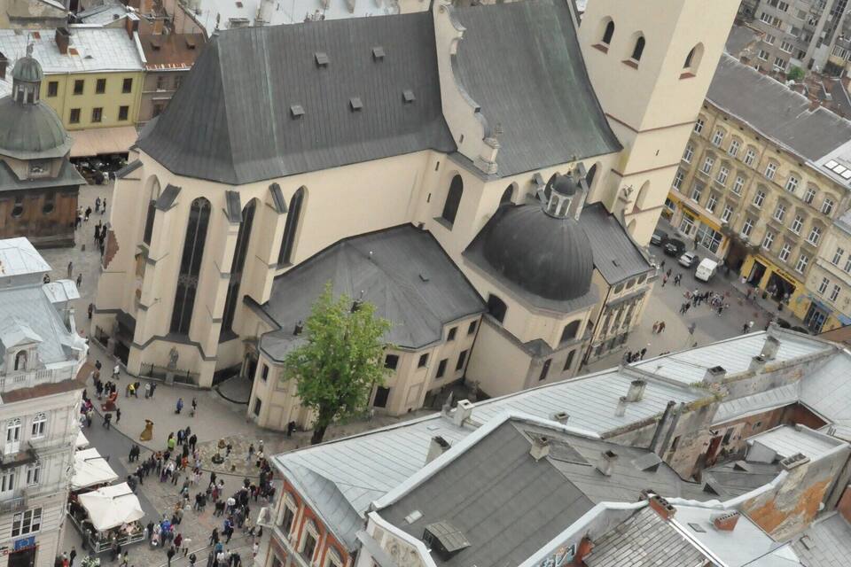 Una vista aerea di un'antica piazza cittadina, con una chiesa imponente e gli edifici circostanti.
