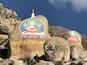 Large rocks with colorful religious paintings and inscriptions.