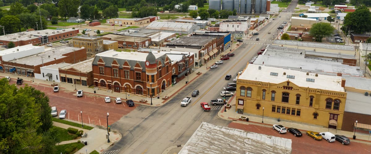 A town with historic buildings, a main street, and industrial facilities in the background.