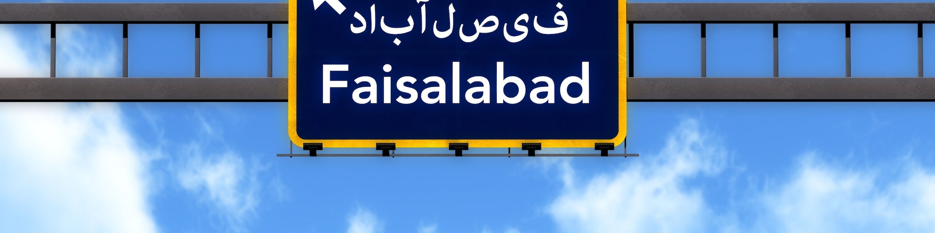 A road sign with the text "Faisalabad" and an arrow pointing left.