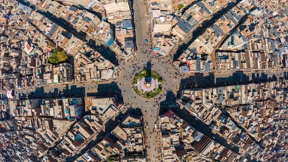 Une vue dâensemble dâune zone urbaine densĂ©ment peuplĂ©e, avec un rond-point central, de nombreux immeubles et un rĂ©seau de rues.