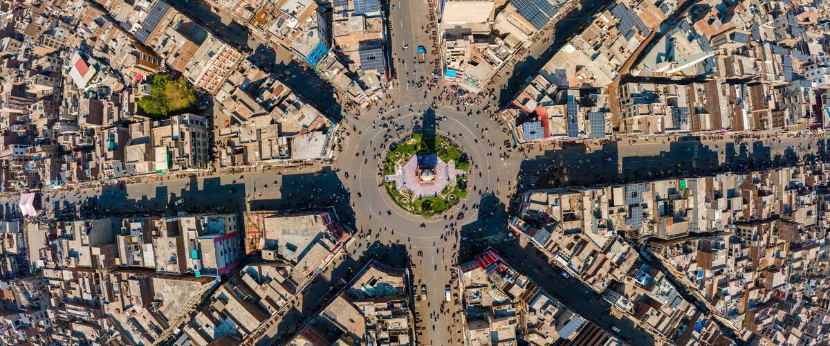 Aerial view of the Clock Tower Faisalabad and its iconic eight radiating streets surrounded by dense urban architecture and rooftops in Faisalabad, Punjab, Pakistan.