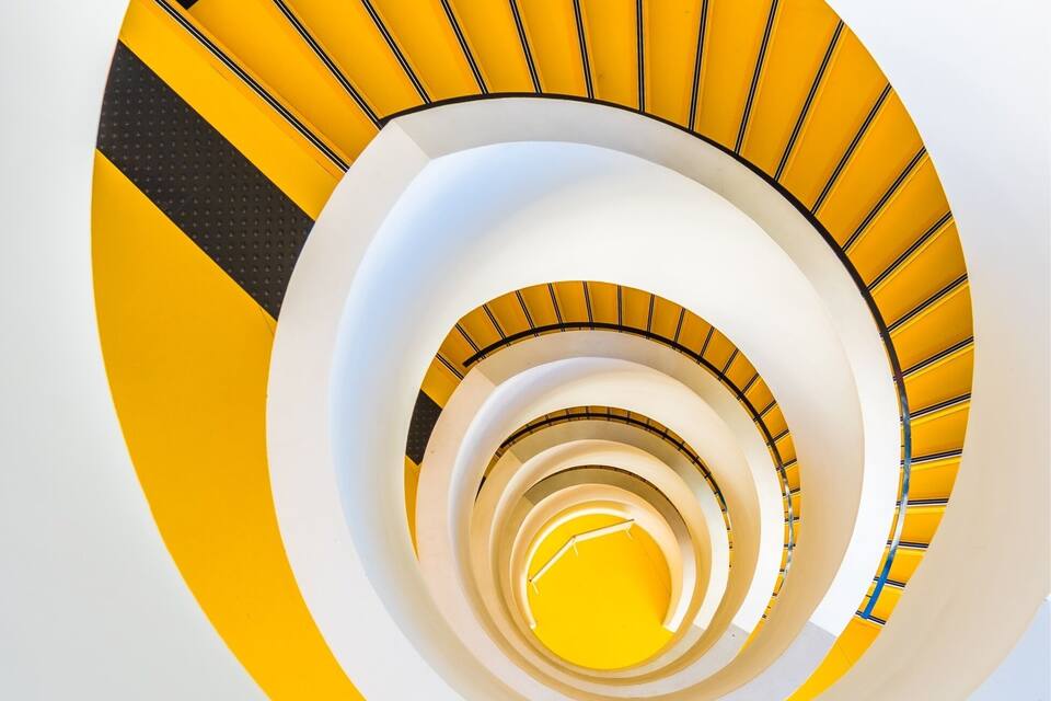 A spiral staircase with yellow and white steps.