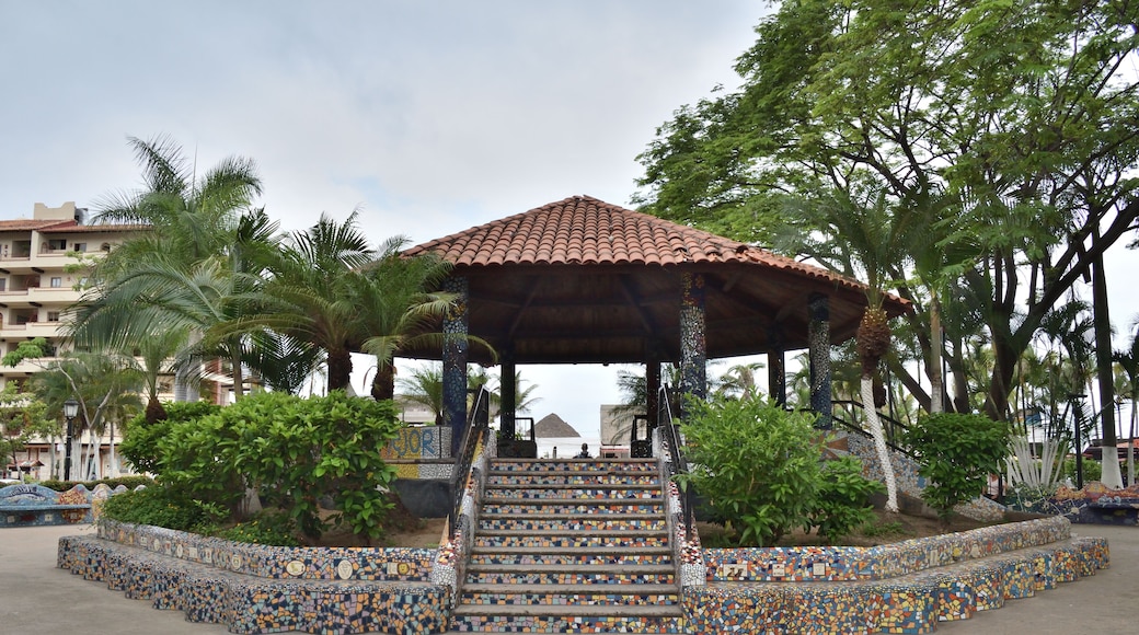 Full view of a mosaic-decorated gazebo surrounded by lush greenery in Lazaro Cardenas Park, under a cloudy sky