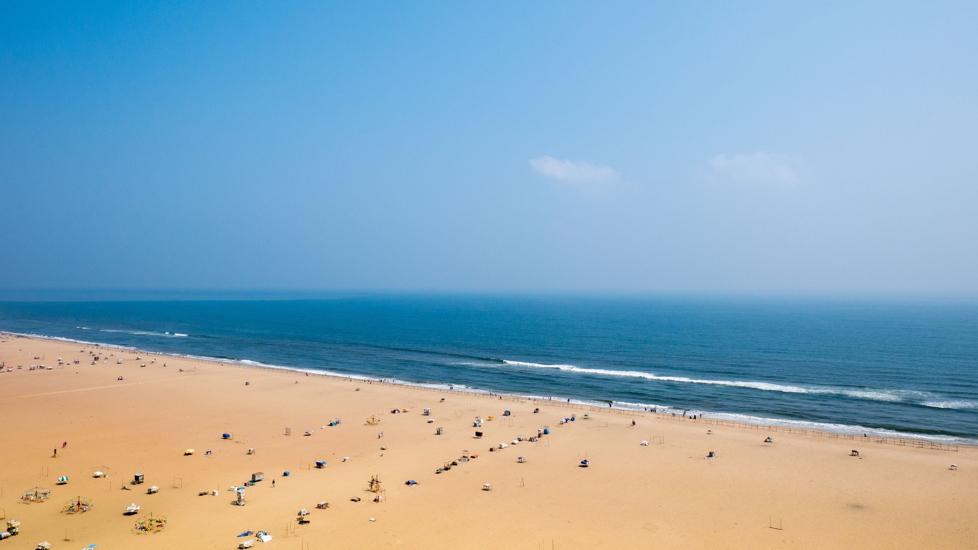 Une vaste plage de sable fin, avec une mer calme et un ciel dégagé.