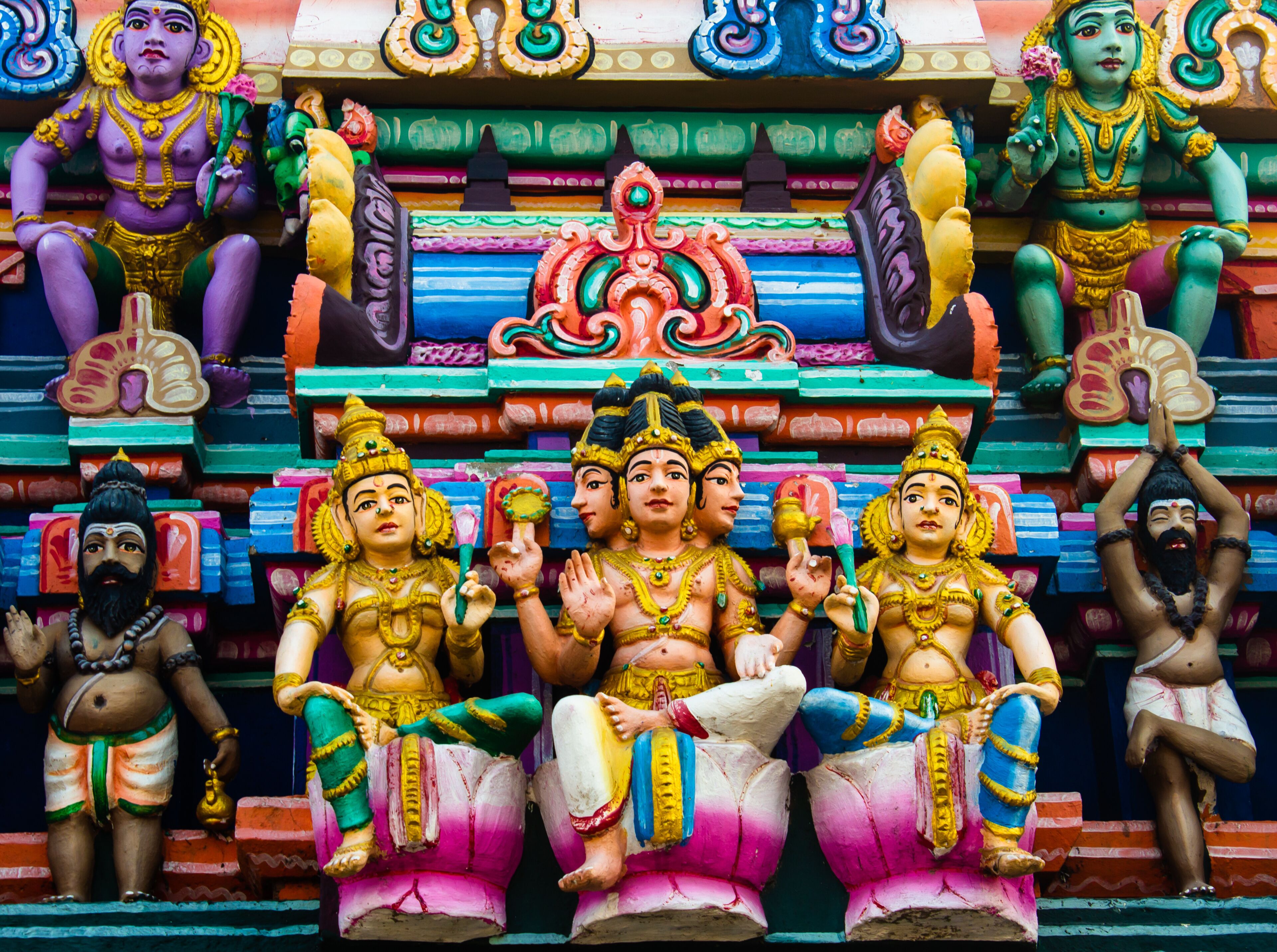 Un temple aux couleurs vives, orné de nombreuses statues de divinités.