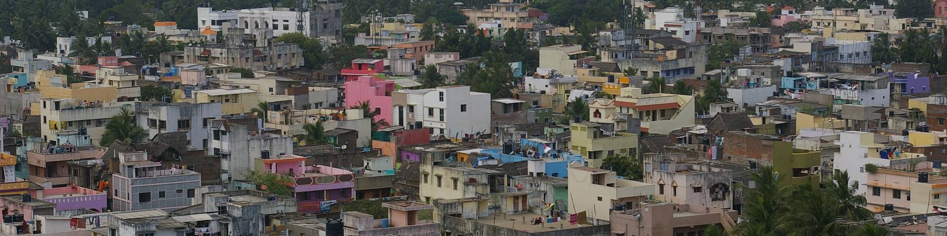 A densely packed urban area with a variety of colorful buildings and a prominent Arvind Residence sign.