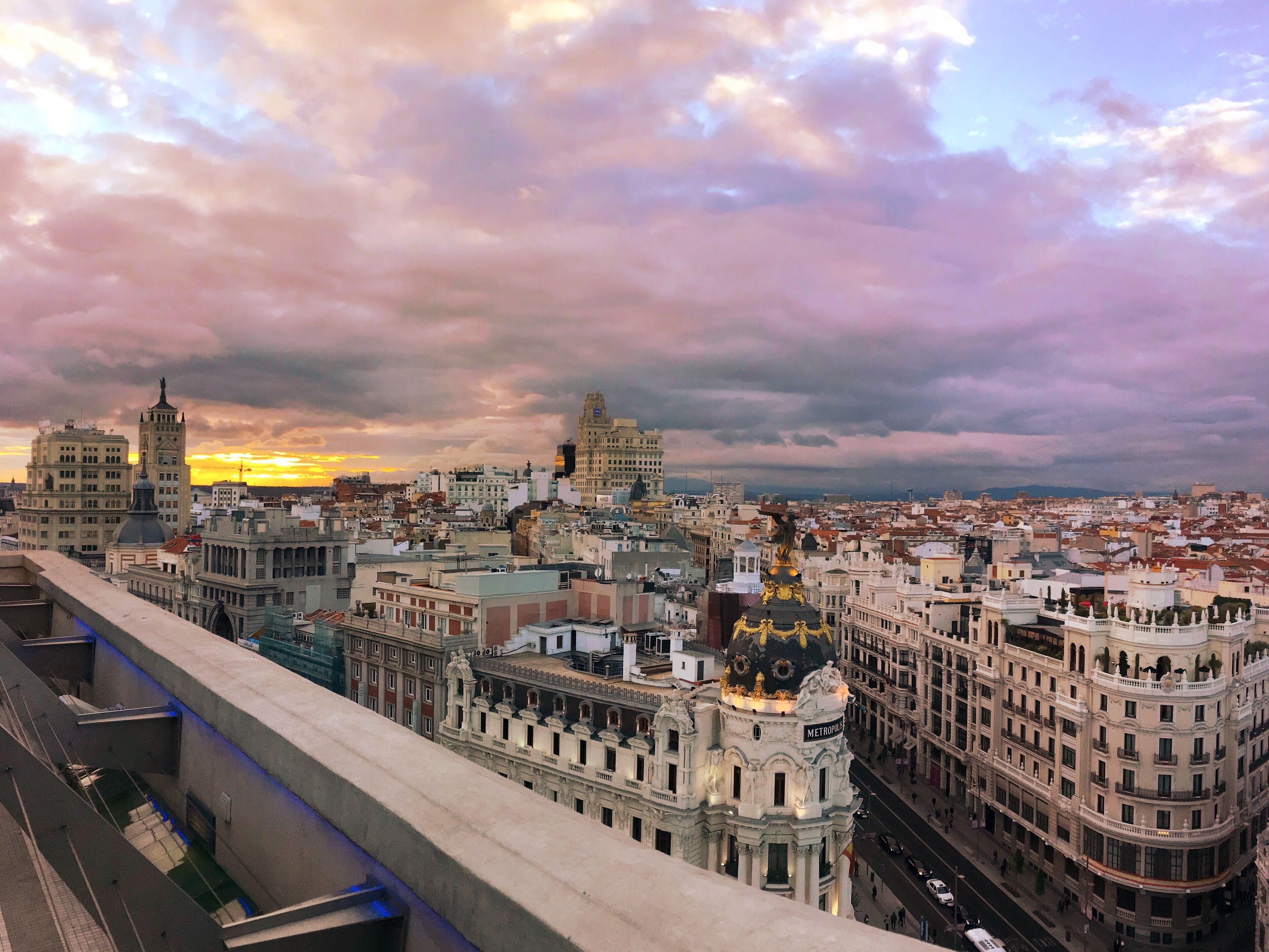 Paisagem urbana com edifícios históricos e um pôr do sol.
