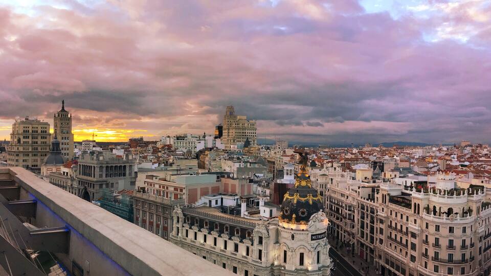 Paisagem urbana com edifícios históricos e um pôr do sol.