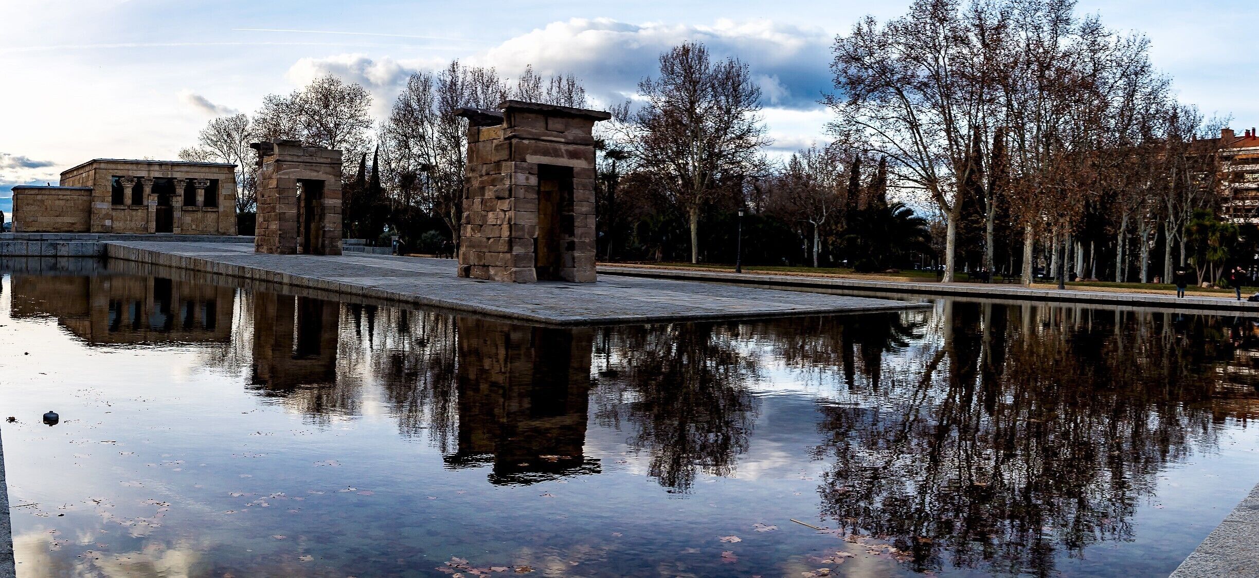 During my visit to Madrid I visited of course the Temple of Debod. It's fascinating to find a original Egyptian Temple outside of Egypt. 
According to Wikipedia and the guide this is what happend and some information about the temple.

The Temple of Debod (Spanish: Templo de Debod) is an ancient Egyptian temple that was dismantled and rebuilt in Madrid, Spain.

Temple of Debod in Egypt before relocation to Spain.The shrine was originally erected 15 kilometres  south of Aswan in Upper Egypt, very close to the first cataract of the Nile and to the great religious center in Philae dedicated to the goddess Isis. In the early 2nd century BC, Adikhalamani (Tabriqo), the Kushite king of Meroë, started its construction by building a small single-room chapel dedicated to the god Amun. It was built and decorated in a similar design to the later Meroitic chapel on which the Temple of Dakka is based. Later, during the reigns of Ptolemy VI, Ptolemy VIII, and Ptolemy XII of the Ptolemaic dynasty, it was extended on all four sides to form a small temple, 12 by 15 metres (39 ft × 49 ft), which was dedicated to Isis of Philae. The Roman emperors Augustus and Tiberius completed its decorations.
From the quay, there is a long processional way leading to the stone-built enclosure wall, through three stone pylon gateways, and finally to the temple itself. The pronaos, which had four columns with composite capitals, collapsed in 1868 and is now lost. Behind it lay the original sanctuary of Amun, the offering table room and a later sanctuary with several side-rooms and stairs to the roof.

The current Temple of Debod in Madrid.
In 1960, due to the construction of the Aswan High Dam and the consequent threat posed by its reservoir to numerous monuments and archeological sites, UNESCO made an international call to save this rich historical legacy. As a sign of gratitude for the help provided by Spain in saving the Abu Simbel temples, the Egyptian state donated the temple of Debod to Spain in 1968.
The temple was rebuilt in one of Madrid's parks, the Parque del Oeste, near the Royal Palace of Madrid, and opened to the public in 1972. The reassembled gateways have been placed in a different order than when originally erected. Compared to a photo of the original site, the gateway topped by a serpent-flanked sun was not the closest gateway to the temple proper. It constitutes one of the few works of ancient Egyptian architecture that can be seen outside Egypt and the only one of its kind in Spain.