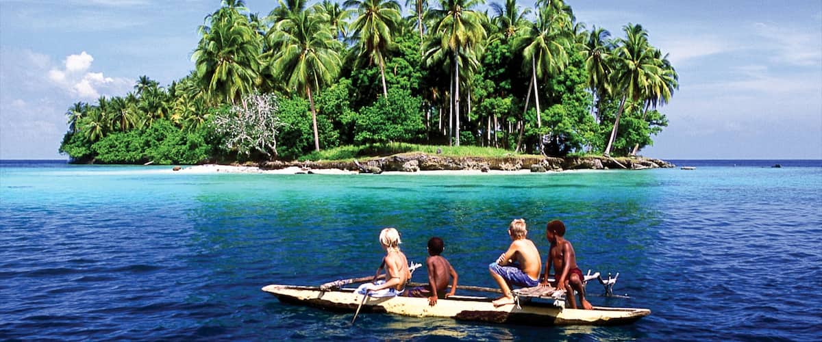 A tropical island with palm trees and clear blue waters.