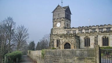 Um edifício histórico de pedra com uma torre do relógio e janelas em arco.