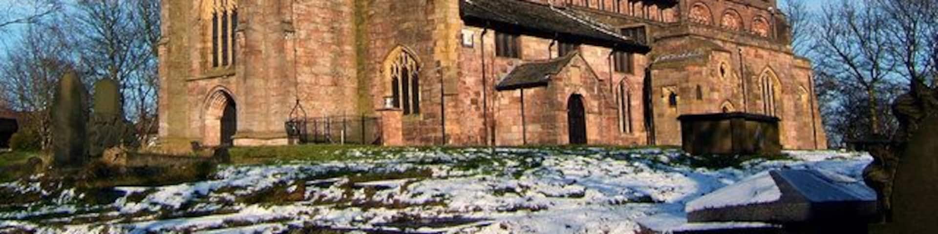 A historic church with a tall tower and arched windows.