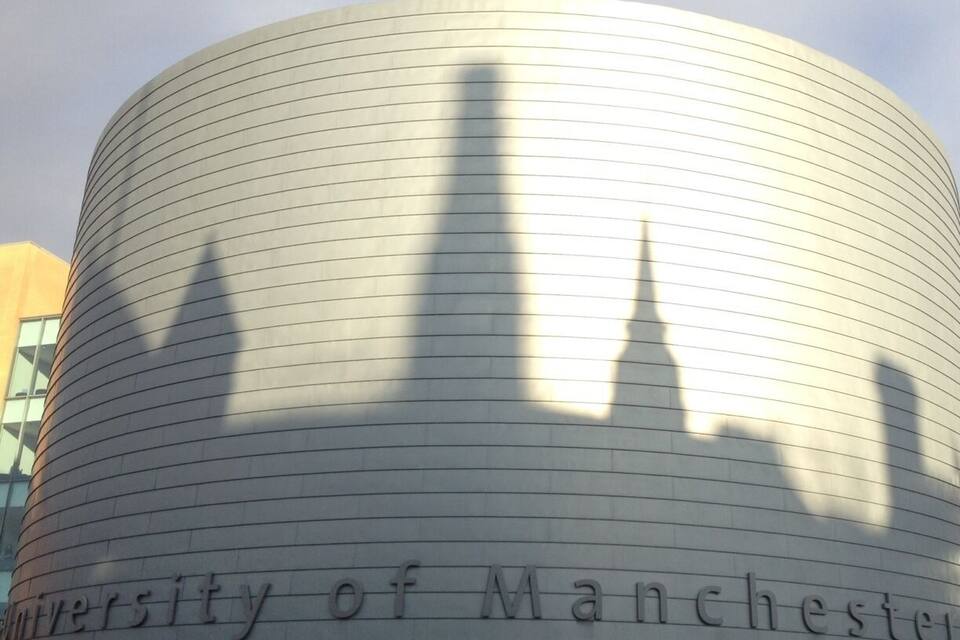 The University of Manchester building with a curved facade and the name inscribed on it.