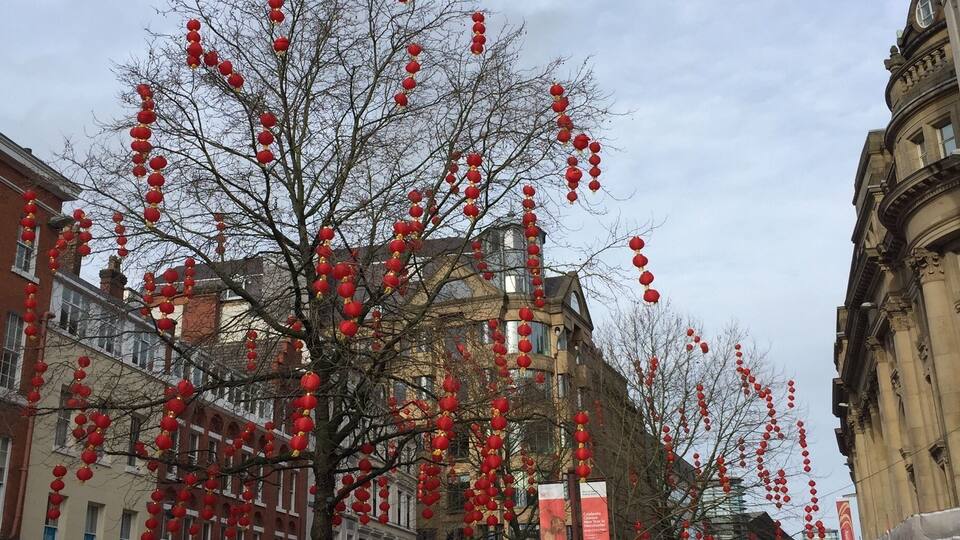 A street lined with red lanterns and buildings.