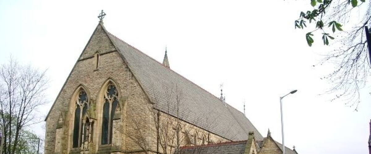 A stone church with a pointed roof and arched windows.