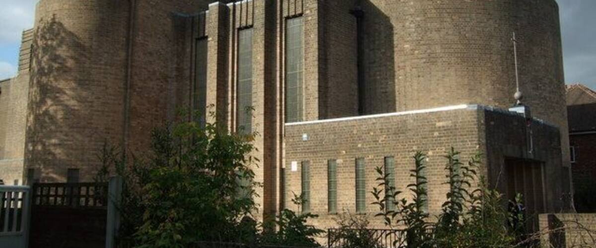 A large brick building with cylindrical towers and rectangular windows.