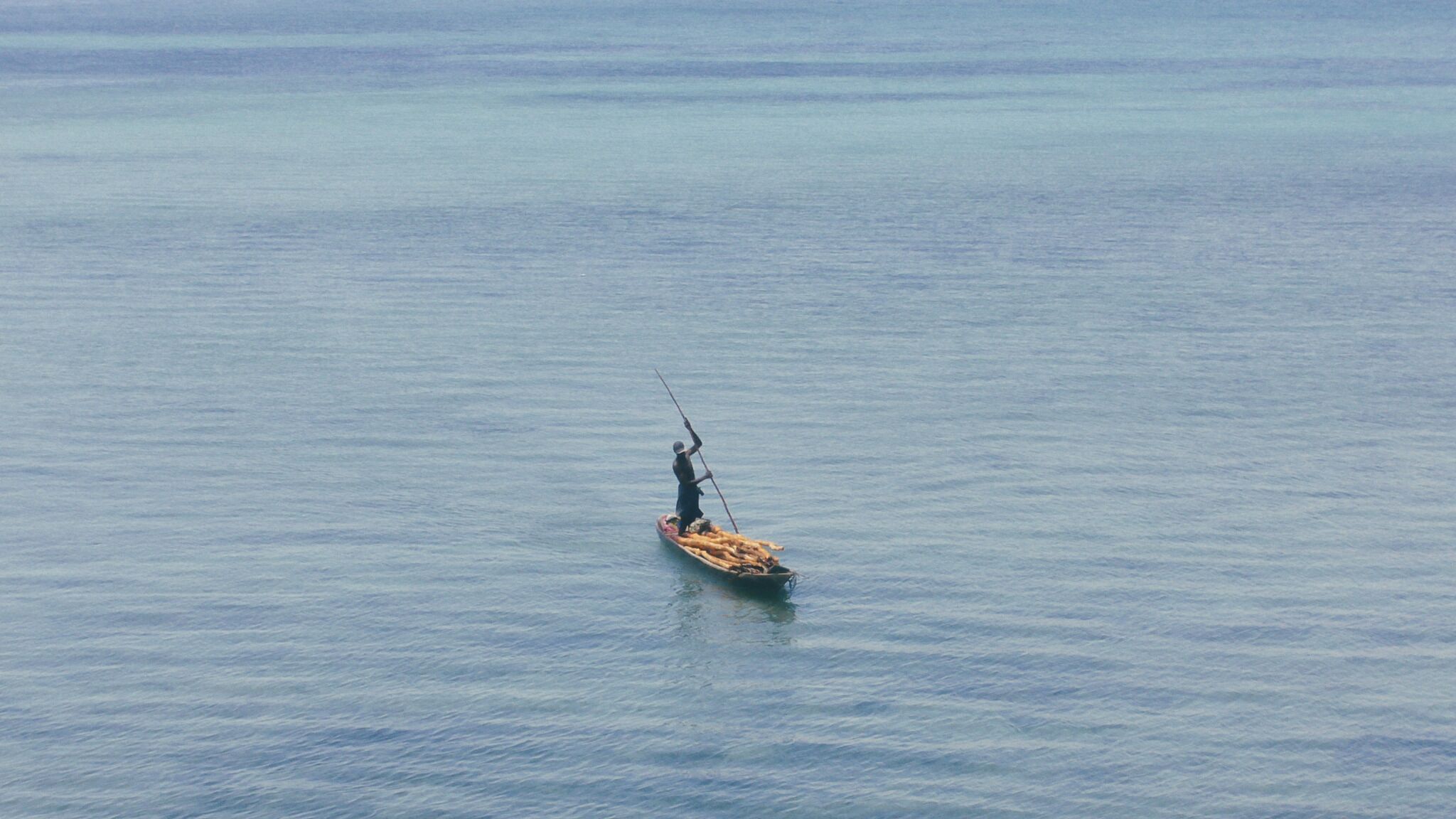 A person fishing in a calm body of water.