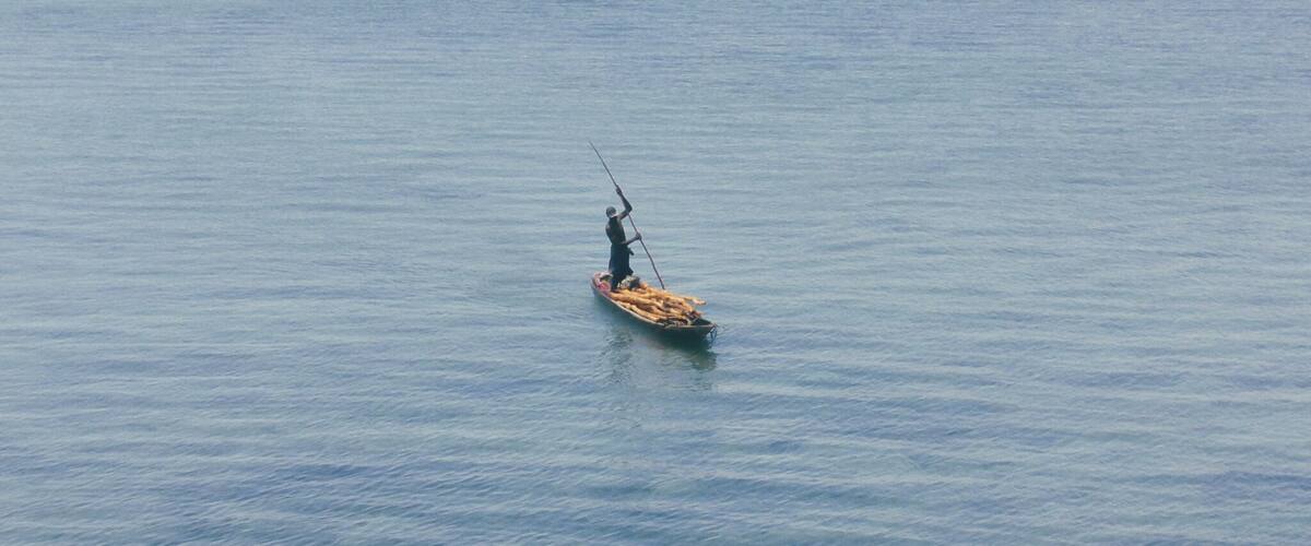 A person fishing in a calm body of water.