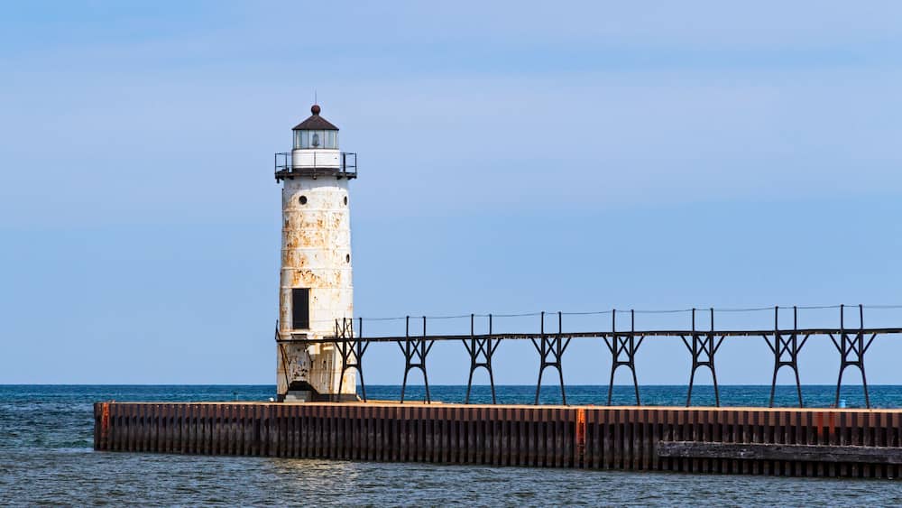 The Lighthouse at Manistee, Michigan with its elevated catwalk approach, is situated upon a breakwater that extends into Lake Michigan