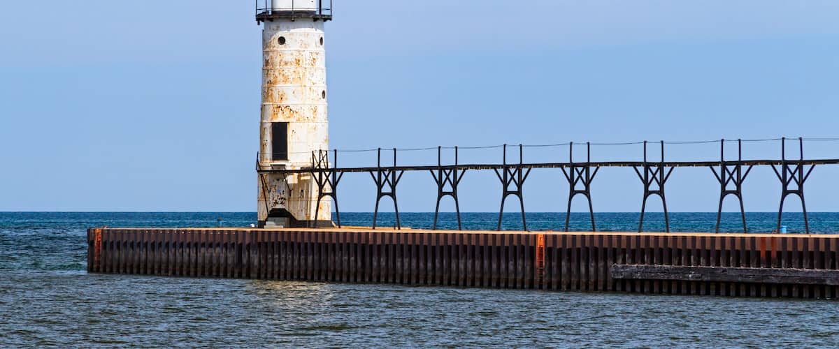 The Lighthouse at Manistee, Michigan with its elevated catwalk approach, is situated  upon a breakwater that extends into Lake Michigan
