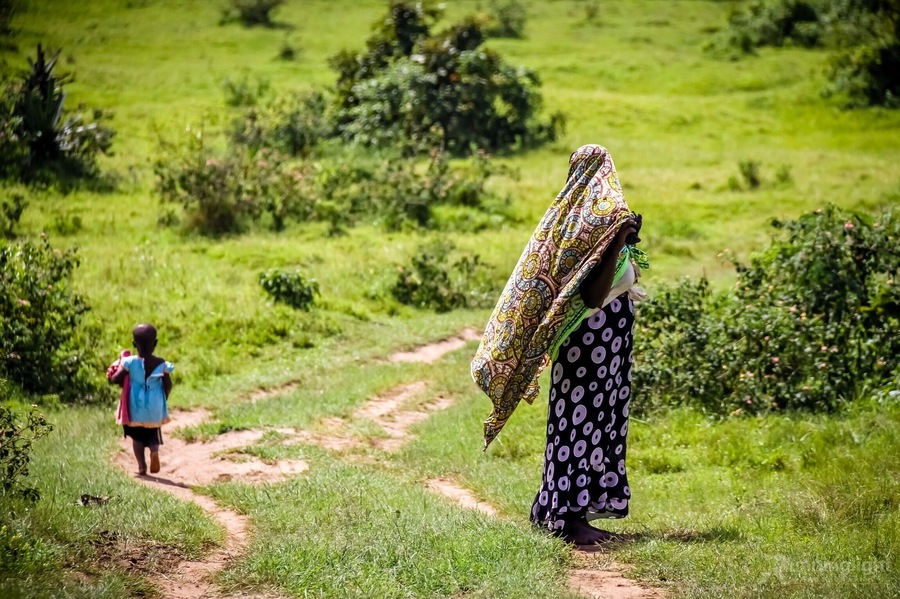 Whilst on a trip to Uganda visiting a rural community watching an NGo drilling for fresh water, I watched a lady beautifully dressed and her child walking along a road on their way home. 
_____________________
Mbarara ~ Uganada Africa