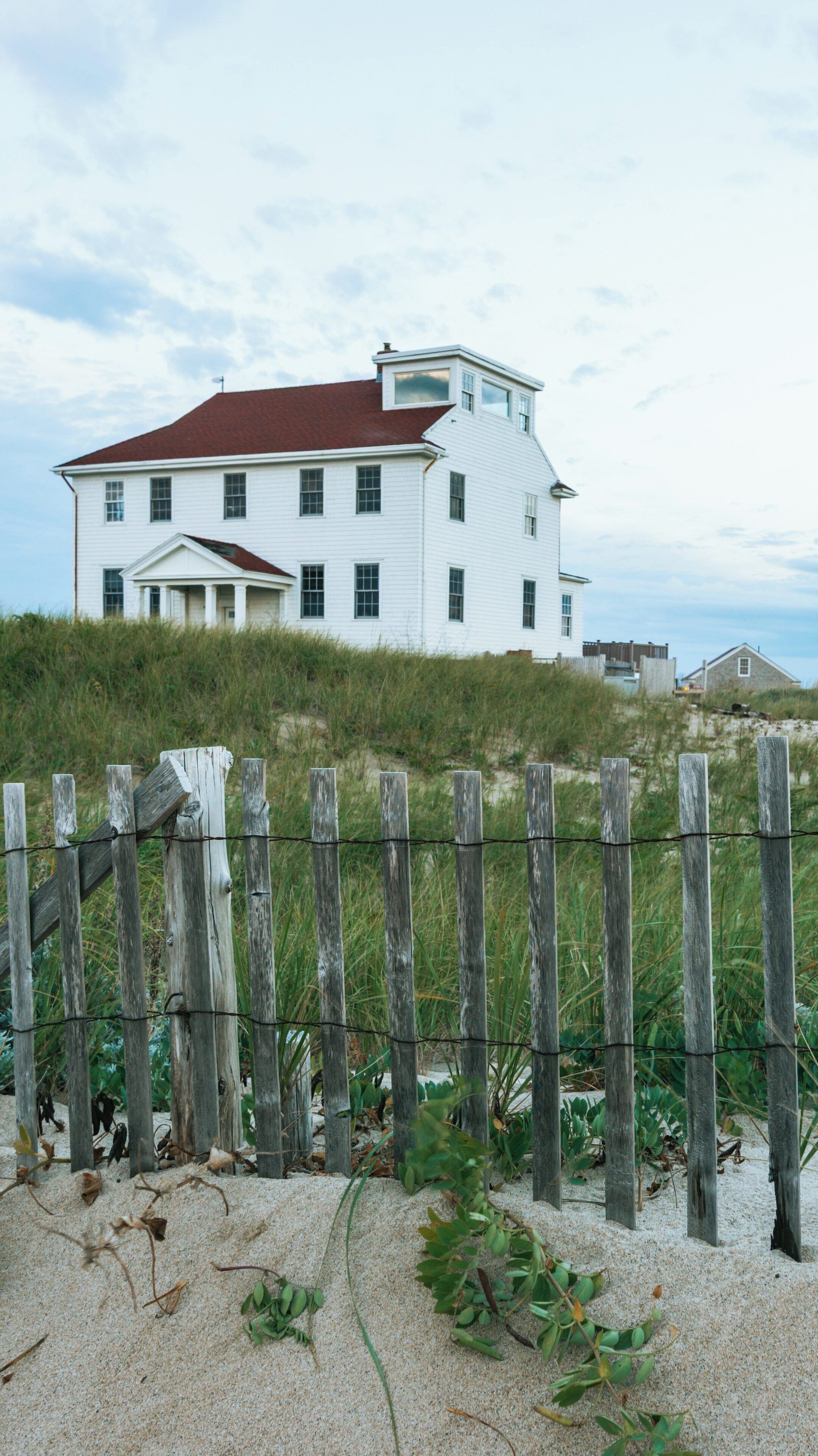 Coastal dunes and classic architecture at Race Point Beach in Provincetown, Massachusetts under a cloudy sky