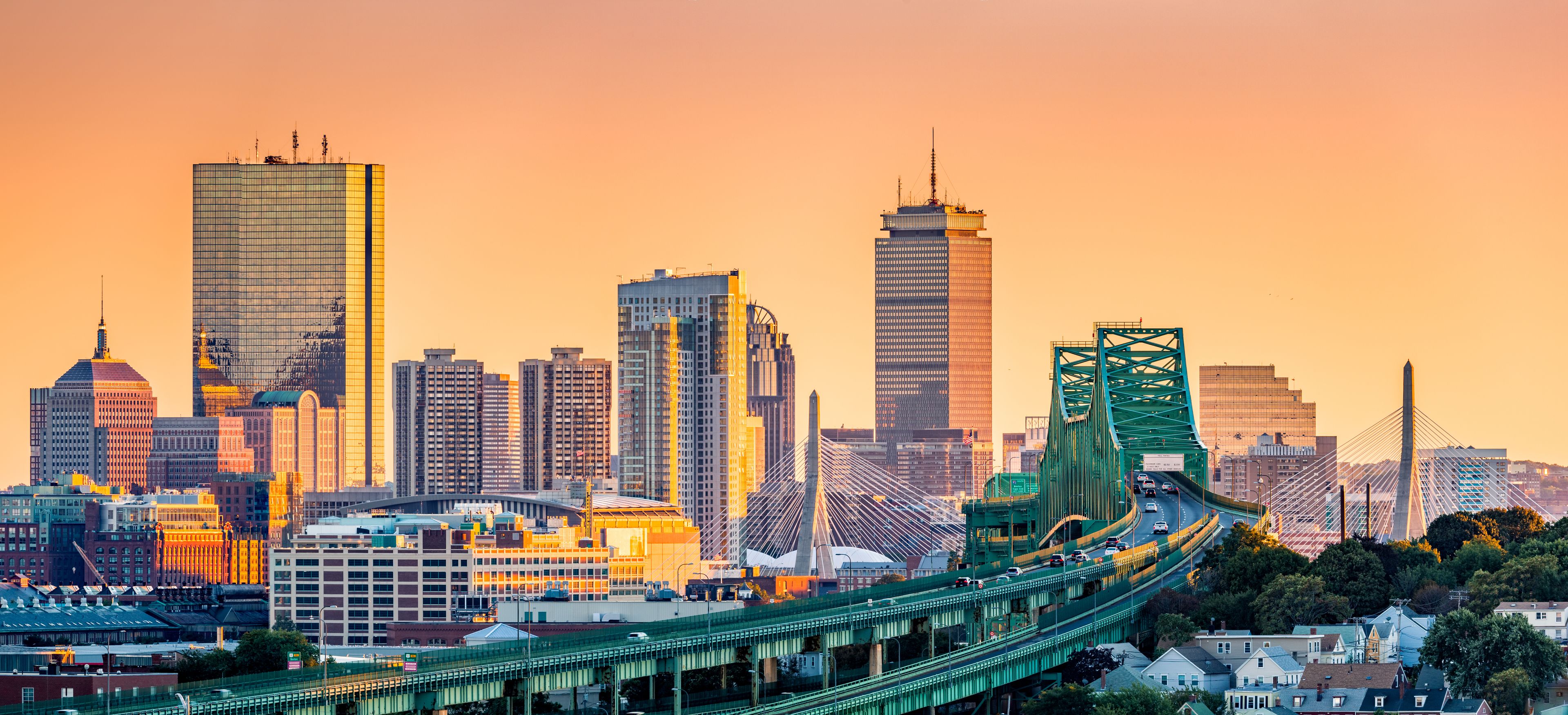 A city skyline with modern skyscrapers and a prominent green bridge.